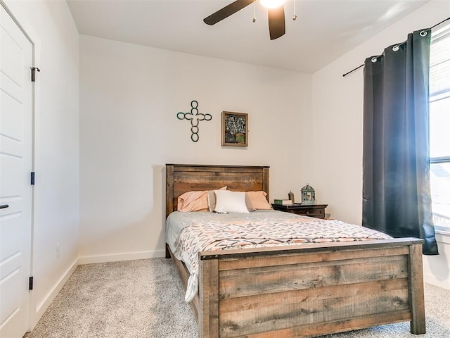 carpeted bedroom with a ceiling fan, baseboards, and multiple windows
