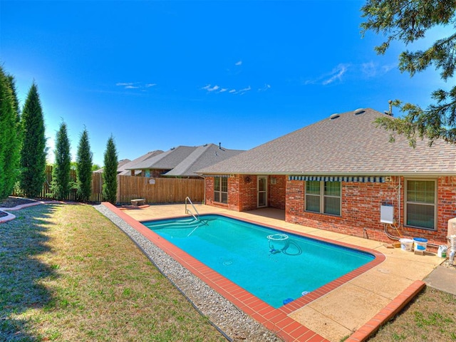 view of swimming pool featuring a fenced backyard, a fenced in pool, a patio, and a lawn
