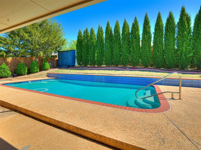 view of pool with an outdoor structure, a storage shed, and a fenced backyard