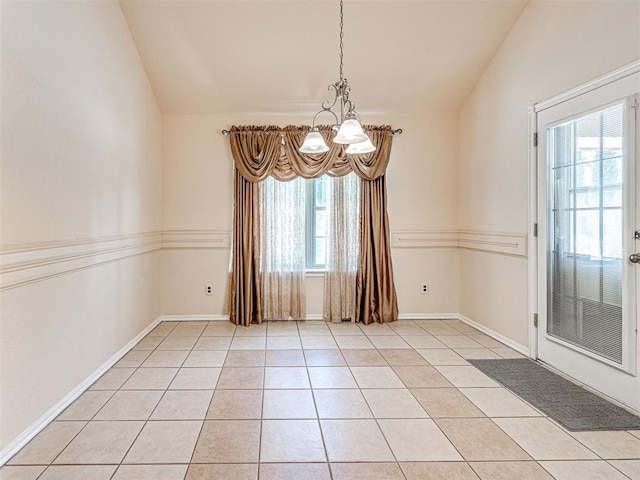 unfurnished room featuring a notable chandelier, plenty of natural light, and lofted ceiling