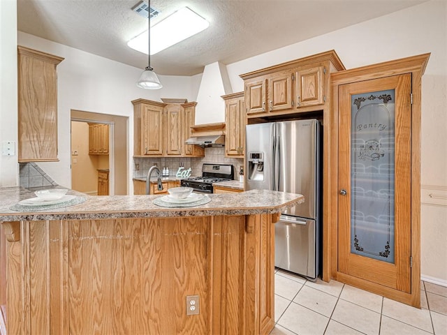 kitchen with visible vents, a peninsula, light tile patterned flooring, ventilation hood, and stainless steel appliances