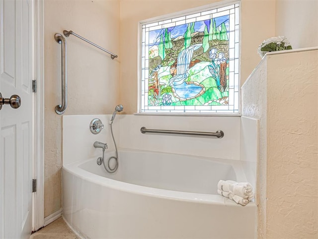 full bath with a textured wall and a bath