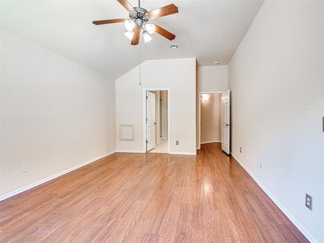 unfurnished bedroom featuring baseboards, visible vents, vaulted ceiling, and light wood-style floors