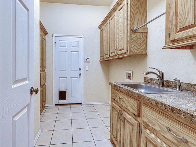 laundry room featuring light tile patterned flooring, baseboards, a sink, cabinet space, and washer hookup