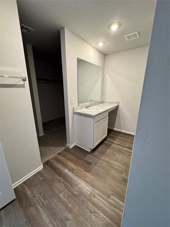 437 Kale Rd, Tuttle, OK 73089 - bathroom featuring vanity, wood finished floors, baseboards, and a spacious closet