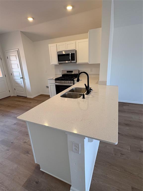424 Kale Rd, Tuttle, OK 73089 - kitchen with appliances with stainless steel finishes, white cabinetry, dark wood-type flooring, recessed lighting, and a peninsula