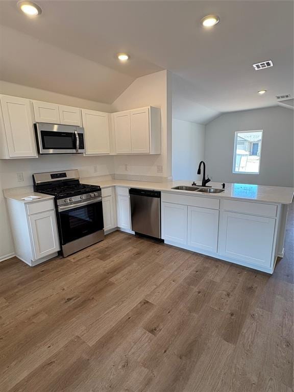 424 Kale Rd, Tuttle, OK 73089 - kitchen featuring stainless steel appliances, lofted ceiling, white cabinetry, a peninsula, and light countertops