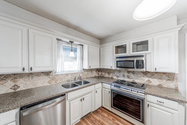 237 E 30th St, Edmond, OK 73013 - kitchen with appliances with stainless steel finishes, a sink, white cabinets, and light wood finished floors