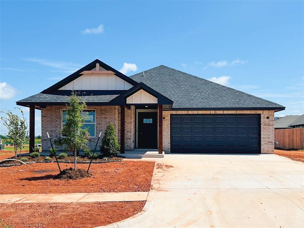 12024 NW 121st Cir, Yukon, OK 73099 - view of front facade with brick siding, driveway, roof with shingles, an attached garage, and board and batten siding