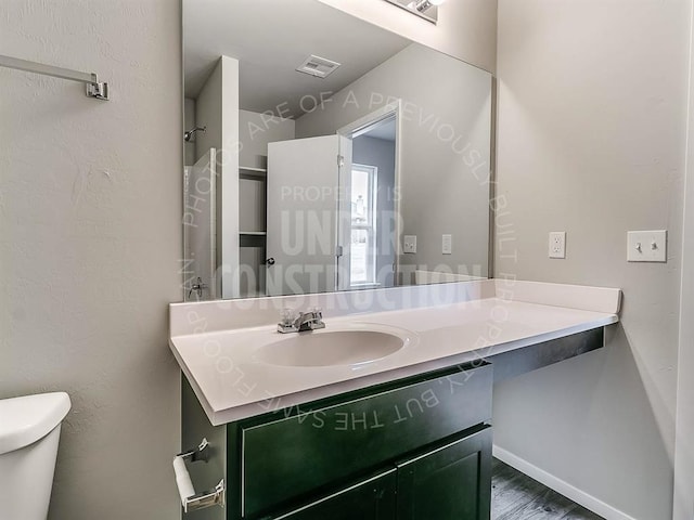 3813 S Ravine St, Stillwater, OK 74074 - bathroom featuring visible vents, baseboards, toilet, wood finished floors, and vanity