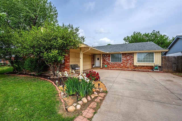 ranch-style home with driveway, a front yard, a garage, brick siding, and fence