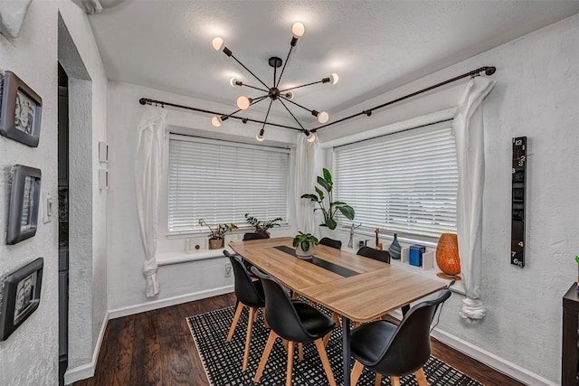 dining area with an inviting chandelier, baseboards, a textured wall, and wood finished floors