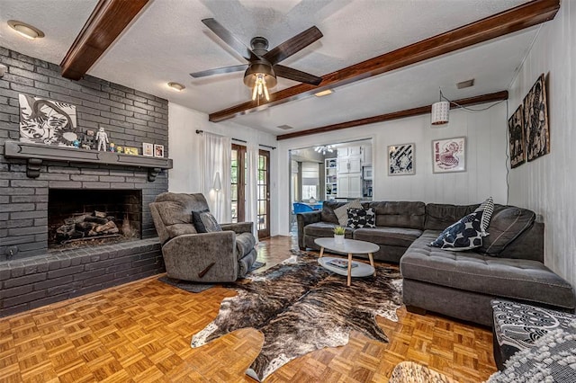 living area featuring a ceiling fan, a textured ceiling, beam ceiling, and a fireplace