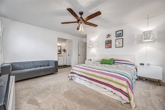 bedroom with ensuite bathroom, a ceiling fan, and carpet flooring