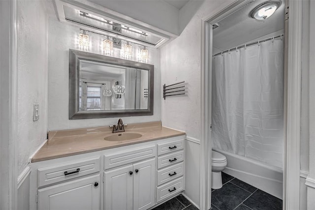 bathroom with vanity, a textured wall, shower / bath combination with curtain, toilet, and tile patterned floors