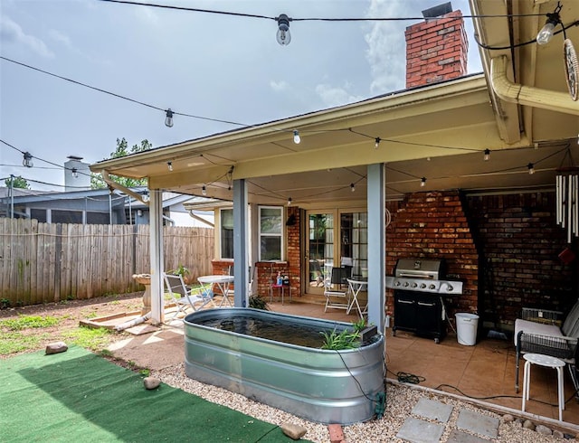 view of patio / terrace with fence and a grill