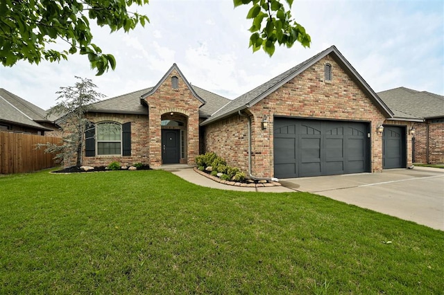 view of front facade with concrete driveway, roof with shingles, a front yard, fence, and a garage