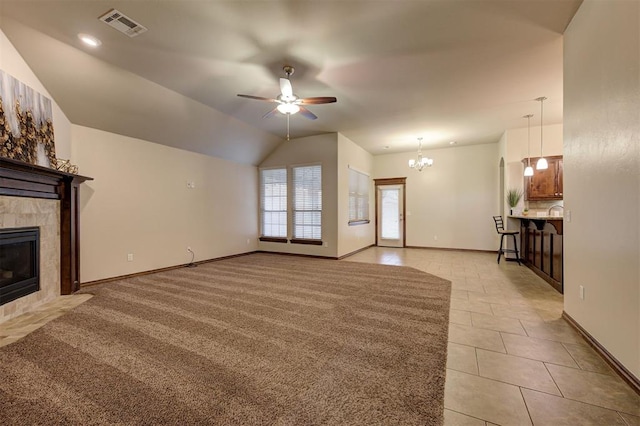 unfurnished living room with lofted ceiling, light tile patterned floors, visible vents, a fireplace, and ceiling fan with notable chandelier