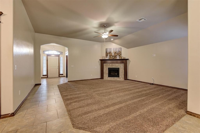 unfurnished living room with arched walkways, vaulted ceiling, baseboards, visible vents, and a ceiling fan