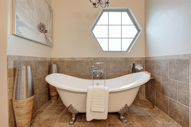 bathroom featuring a freestanding tub, tile walls, and wainscoting