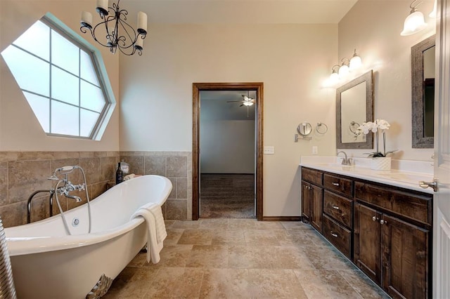 full bath with stone finish floor, a soaking tub, a sink, double vanity, and tile walls