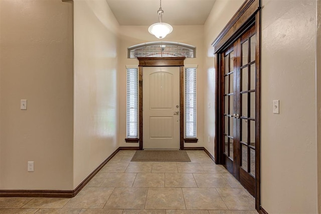 foyer entrance featuring light tile patterned floors and baseboards