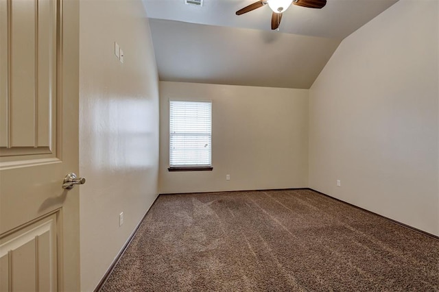 spare room with carpet flooring, visible vents, ceiling fan, baseboards, and vaulted ceiling