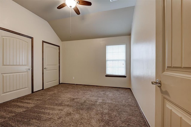 unfurnished bedroom featuring lofted ceiling, carpet, and a ceiling fan