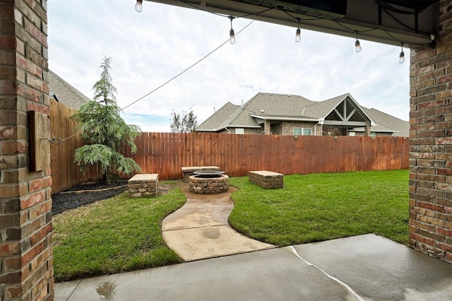 view of yard with a patio, a fenced backyard, and an outdoor fire pit