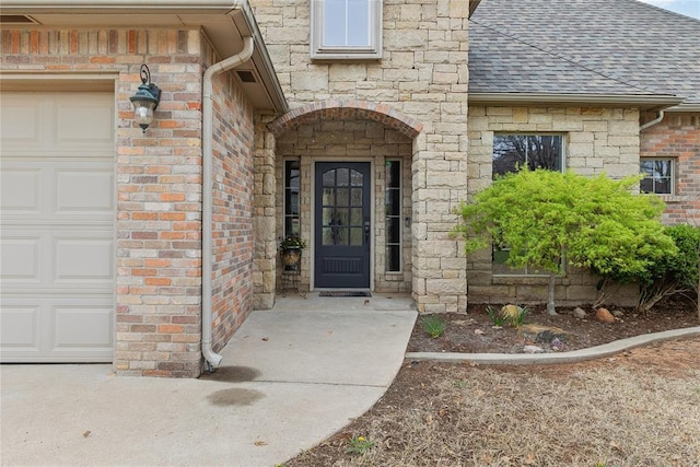 532 Conquistador Ct, Edmond, OK 73025 - view of exterior entry featuring a shingled roof, an attached garage, and brick siding