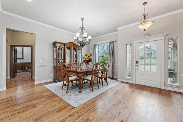 532 Conquistador Ct, Edmond, OK 73025 - dining space featuring light wood finished floors, ornamental molding, a notable chandelier, and baseboards