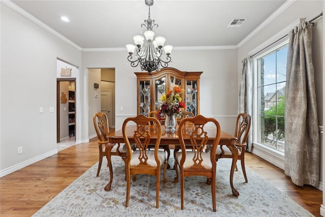 532 Conquistador Ct, Edmond, OK 73025 - dining area featuring visible vents, ornamental molding, an inviting chandelier, and light wood-style flooring