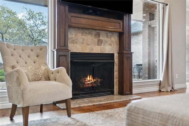 532 Conquistador Ct, Edmond, OK 73025 - interior details featuring baseboards, wood finished floors, and a warm lit fireplace