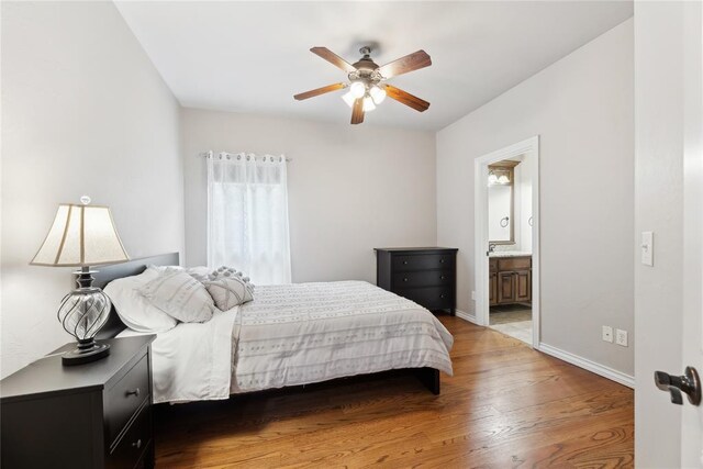 532 Conquistador Ct, Edmond, OK 73025 - bedroom with ensuite bathroom, ceiling fan, wood finished floors, and baseboards
