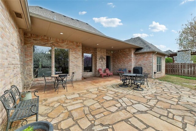 532 Conquistador Ct, Edmond, OK 73025 - view of patio / terrace with fence, outdoor dining space, and visible vents