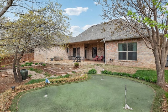 532 Conquistador Ct, Edmond, OK 73025 - rear view of house with fence, roof with shingles, a patio, and brick siding