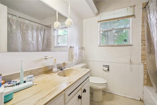 1305 Juniper Cir, Oklahoma City, OK 73110 - full bath featuring vanity, toilet, tile patterned floors, shower / bath combination with curtain, and a wainscoted wall