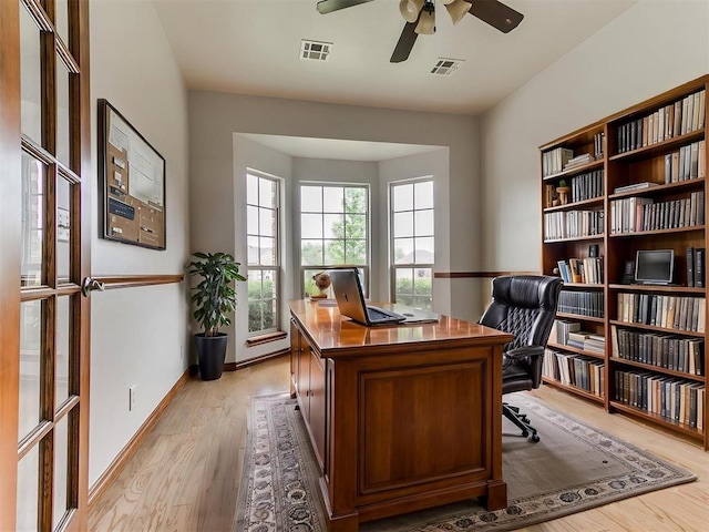 home office with visible vents, light wood-style flooring, and ceiling fan
