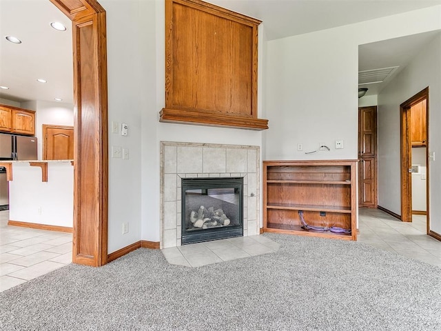 unfurnished living room featuring recessed lighting, baseboards, light tile patterned floors, and light colored carpet