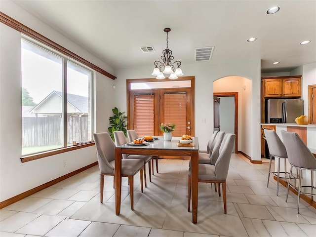 dining room with arched walkways, baseboards, recessed lighting, and visible vents