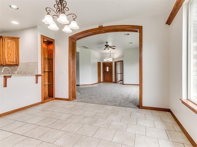unfurnished dining area featuring visible vents, baseboards, recessed lighting, light colored carpet, and ceiling fan with notable chandelier