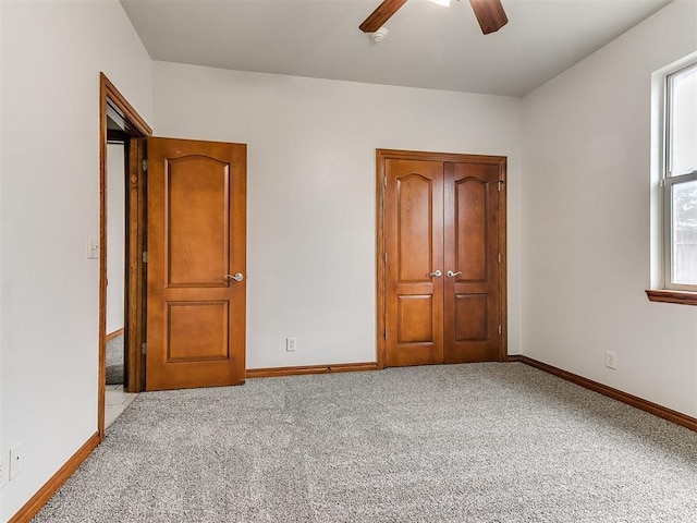 unfurnished bedroom with baseboards, a ceiling fan, and carpet