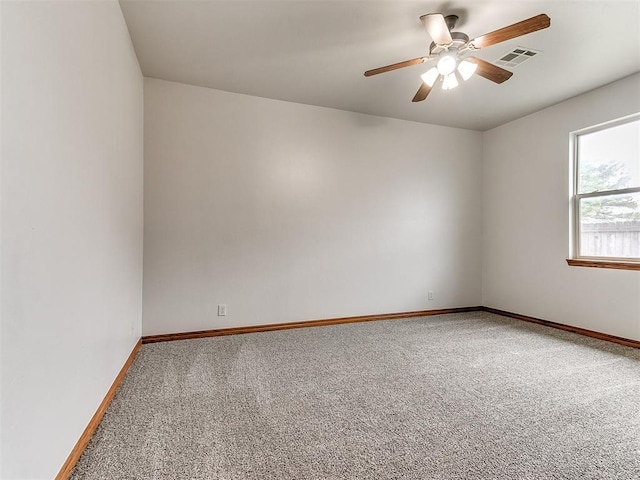 carpeted empty room with a ceiling fan, baseboards, and visible vents