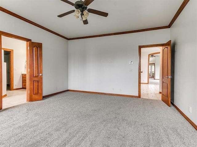 unfurnished room featuring ceiling fan, light colored carpet, light tile patterned floors, baseboards, and ornamental molding