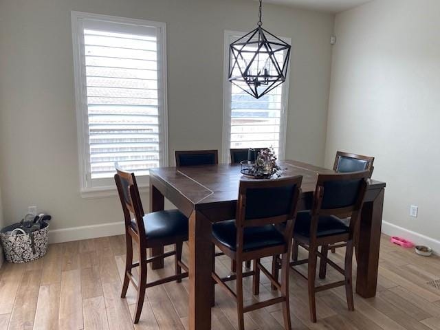 dining space featuring light wood-type flooring and baseboards
