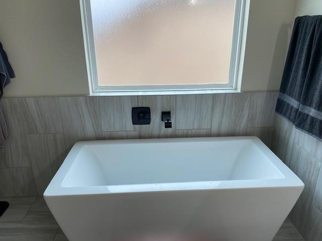 bathroom featuring a freestanding tub and tile patterned flooring