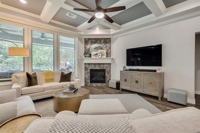 living room with plenty of natural light, ornamental molding, coffered ceiling, and visible vents