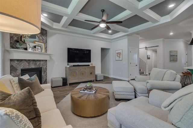 living room featuring crown molding, ceiling fan, a barn door, and coffered ceiling