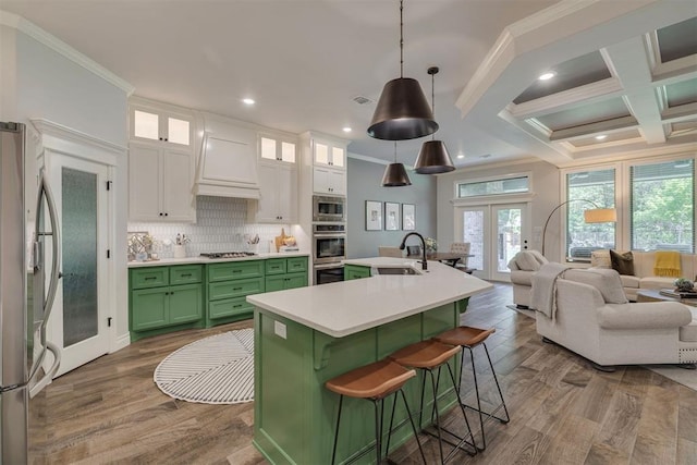 kitchen with ornamental molding, french doors, custom range hood, appliances with stainless steel finishes, and green cabinets