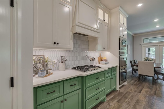 kitchen featuring light countertops, stainless steel appliances, white cabinetry, backsplash, and green cabinets